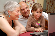grandparents and grandchild watching laptop