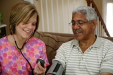 enfermera hogareña controlando la presión sanguínea de un paciente