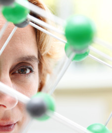 mujer mirando un modelo molecular