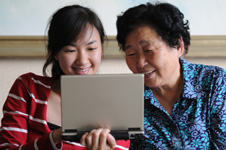 grandmother and granddaughter watching laptop